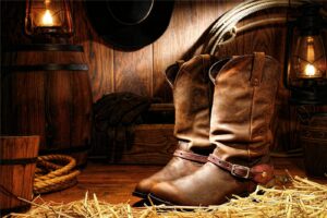 Cowboy boots and hat in a rustic barn