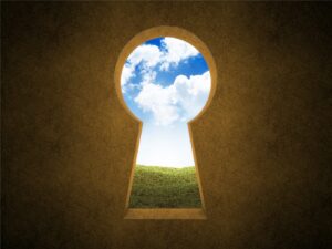 Keyhole shaped opening showing blue sky and a green meadow