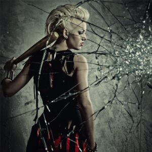 Stylish woman with a bat behind cracked glass